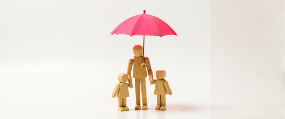 Une famille en figurine en bois portant un parapluie pour protéger les enfants